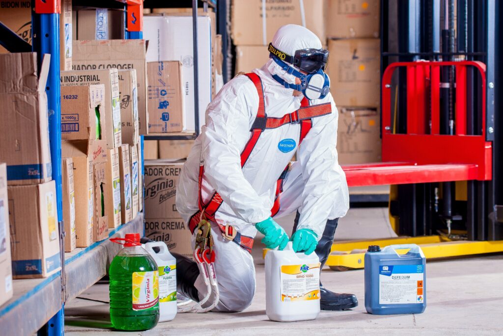 Un employé, équipé, manipulant des produits chimiques dangereux