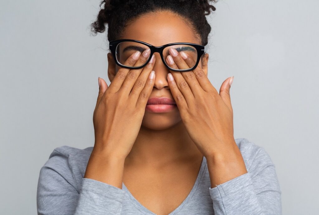 Une femme qui se masse les yeux suite à une fatigue oculaire