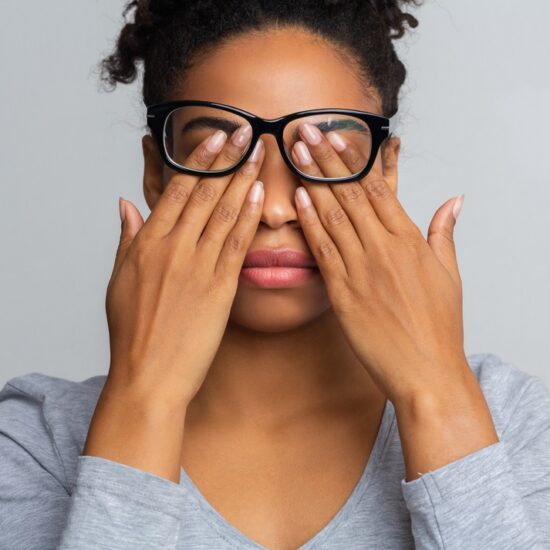Une femme qui se masse les yeux suite à une fatigue oculaire